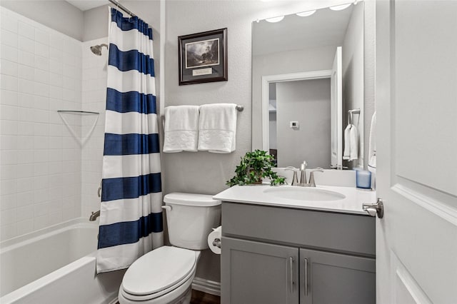 full bathroom featuring toilet, a textured wall, shower / bathtub combination with curtain, and vanity