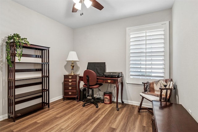 office area with a ceiling fan, baseboards, and wood finished floors