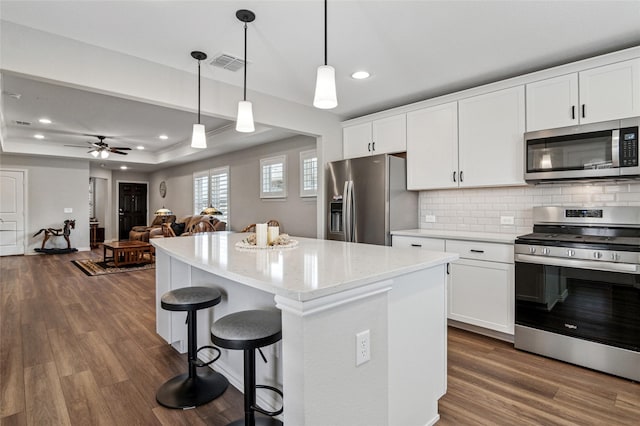 kitchen with open floor plan, stainless steel appliances, and white cabinetry