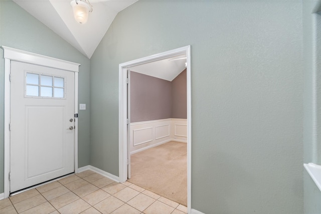 entrance foyer with vaulted ceiling and light carpet