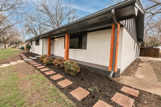 view of side of property featuring brick siding and a porch