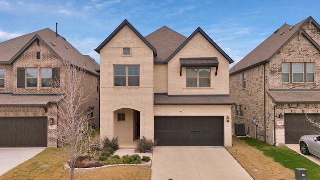 view of front of property featuring central AC unit, a front yard, and a garage