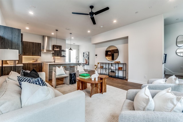 living area featuring light wood-type flooring, recessed lighting, ceiling fan, and baseboards