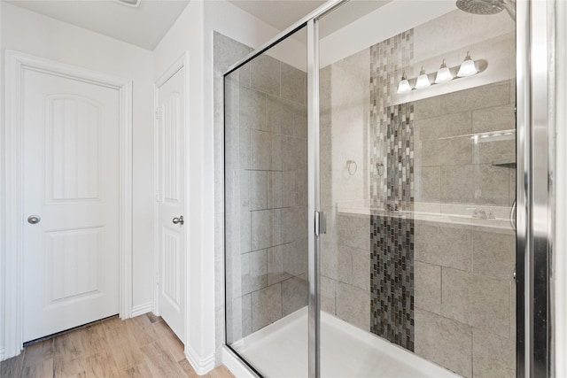 bathroom with a shower stall and wood finished floors