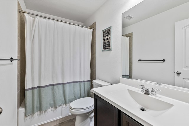 bathroom with visible vents, toilet, wood finished floors, shower / bath combo with shower curtain, and vanity