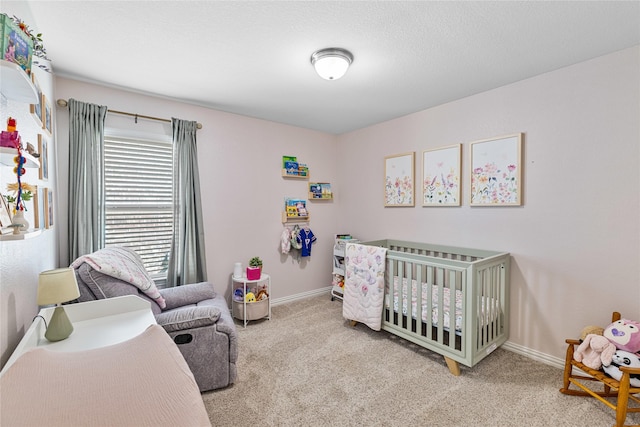 carpeted bedroom featuring a nursery area, a textured ceiling, and baseboards