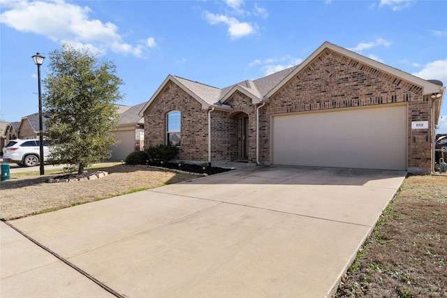 single story home featuring a garage, concrete driveway, brick siding, and roof with shingles