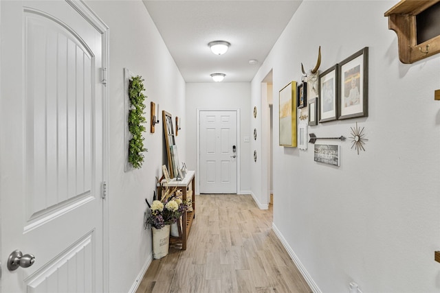 entryway with light wood-style flooring and baseboards