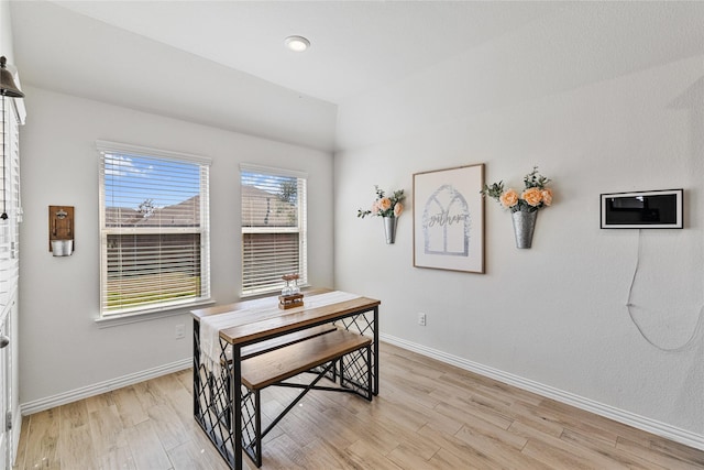 dining space with light wood finished floors and baseboards