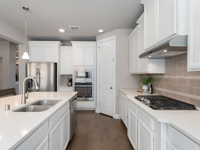 kitchen featuring hanging light fixtures, appliances with stainless steel finishes, extractor fan, white cabinets, and sink