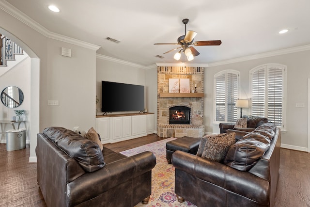 living area featuring ceiling fan, ornamental molding, wood finished floors, and visible vents