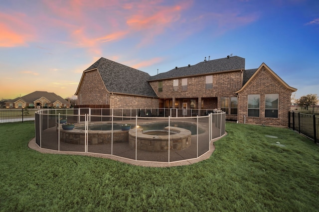 exterior space with a patio area, a fenced backyard, a lawn, and brick siding