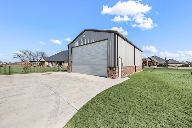 view of outbuilding featuring fence, concrete driveway, and an outdoor structure