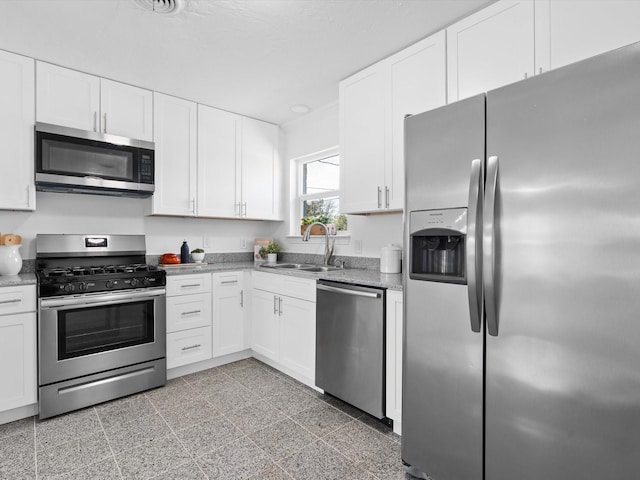 kitchen with appliances with stainless steel finishes, sink, and white cabinets