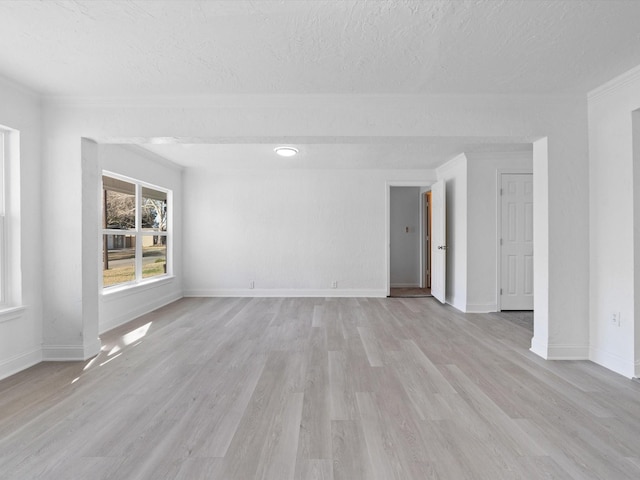 unfurnished room featuring light hardwood / wood-style flooring, a textured ceiling, and ornamental molding