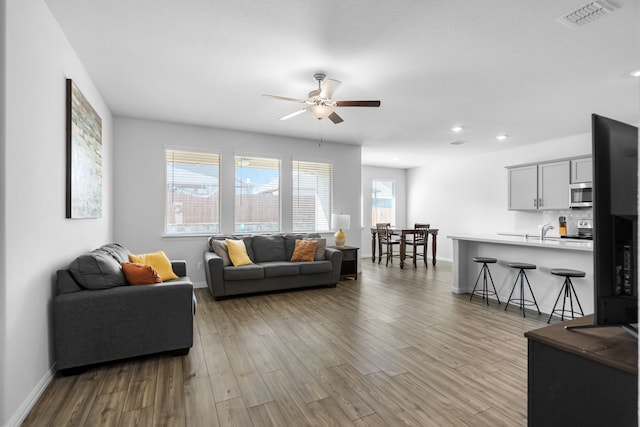 living room featuring baseboards, visible vents, and light wood-type flooring