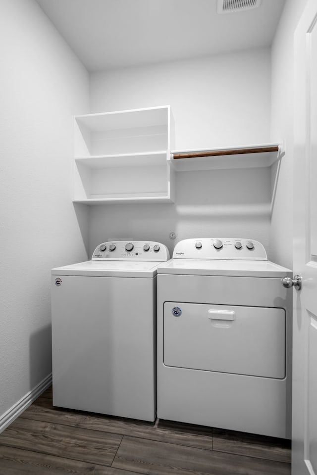 clothes washing area with baseboards, visible vents, separate washer and dryer, dark wood-style flooring, and laundry area