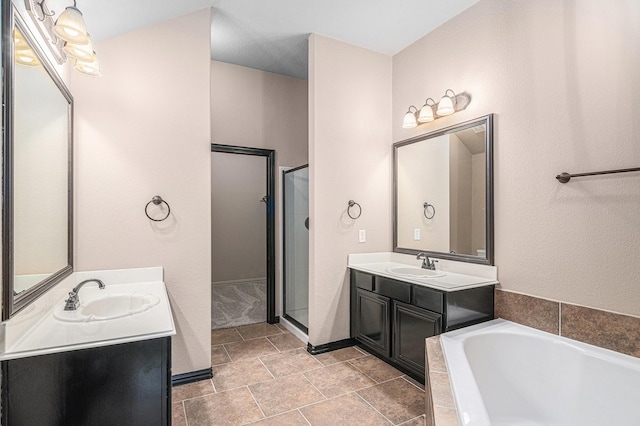 full bath with a sink, two vanities, a garden tub, and a shower stall