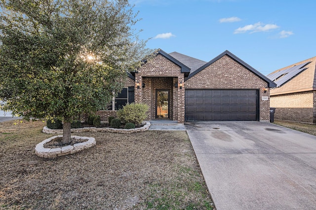 view of front of home featuring brick siding, an attached garage, and driveway