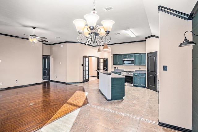 kitchen with dark countertops, crown molding, visible vents, blue cabinetry, and stainless steel stove