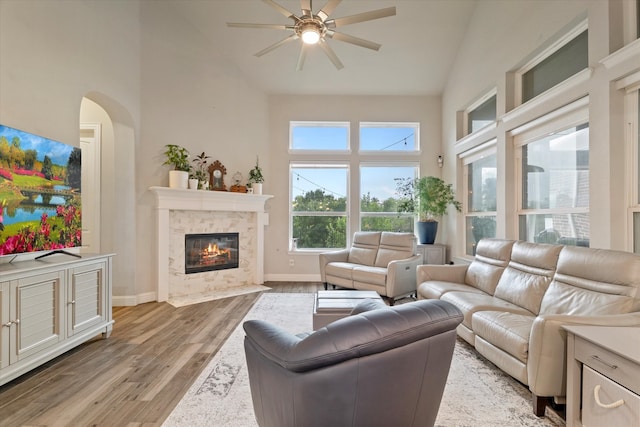 4109 Chantilly Ln, Frisco, TX 75036 - living area with high vaulted ceiling, a ceiling fan, light wood finished floors, a fireplace with flush hearth, and baseboards