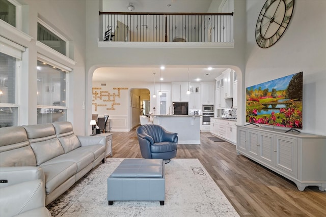 4109 Chantilly Ln, Frisco, TX 75036 - living area featuring arched walkways, a high ceiling, and wood finished floors
