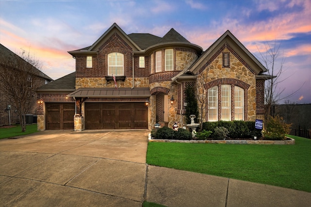 french country style house with driveway, stone siding, a front lawn, and brick siding