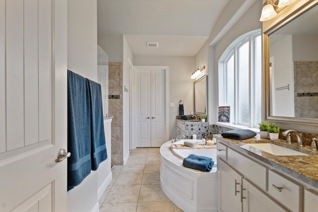 4109 Chantilly Ln, Frisco, TX 75036 - full bathroom featuring a garden tub, walk in shower, two vanities, and tile patterned floors