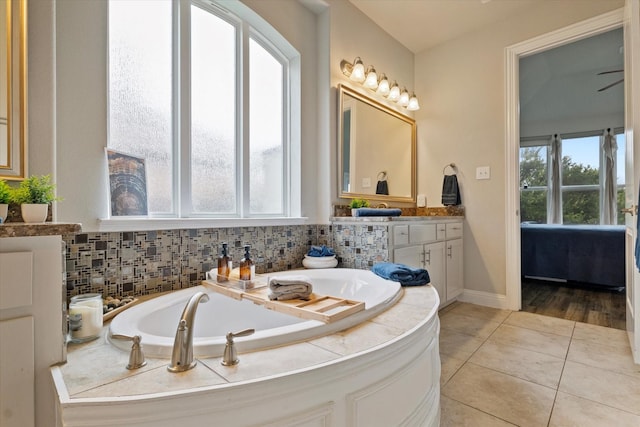 4109 Chantilly Ln, Frisco, TX 75036 - bathroom with a garden tub, vanity, tile patterned flooring, and decorative backsplash