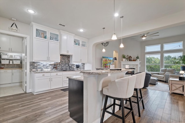 4109 Chantilly Ln, Frisco, TX 75036 - kitchen featuring light wood finished floors, tasteful backsplash, arched walkways, a ceiling fan, and recessed lighting