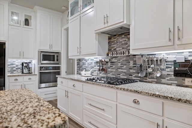 4109 Chantilly Ln, Frisco, TX 75036 - kitchen featuring stainless steel appliances, white cabinets, tasteful backsplash, glass insert cabinets, and light stone countertops