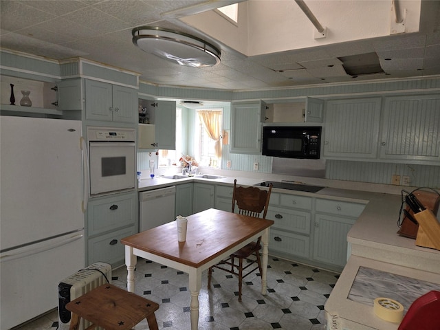 kitchen with light floors, black appliances, light countertops, and open shelves