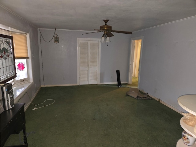 unfurnished living room featuring ornamental molding, baseboards, a ceiling fan, and carpet