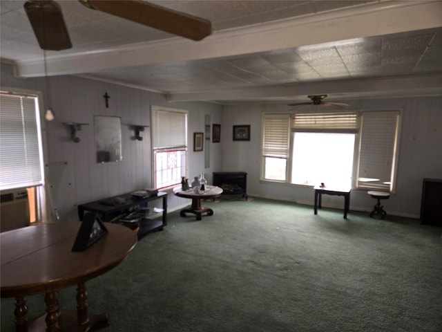 interior space featuring a ceiling fan, carpet floors, beamed ceiling, and plenty of natural light