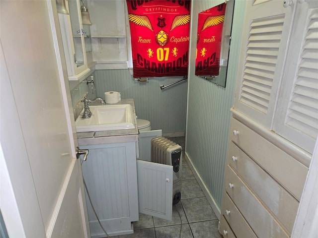 washroom with a sink, radiator heating unit, and tile patterned flooring