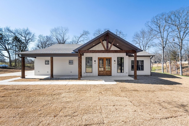 rear view of house with roof with shingles and french doors