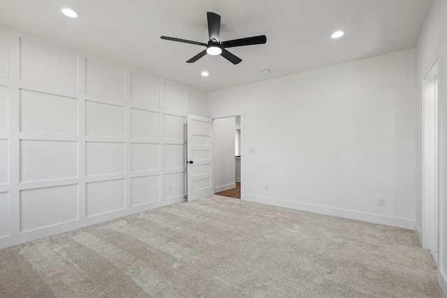 empty room with a decorative wall, carpet floors, a ceiling fan, and recessed lighting