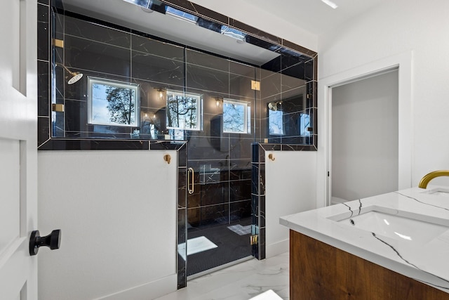 bathroom with a marble finish shower, vanity, and marble finish floor