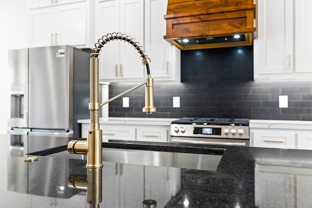 kitchen with tasteful backsplash, custom range hood, white cabinets, and stainless steel range oven