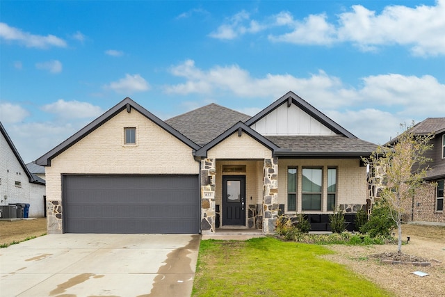 view of front of property featuring roof with shingles, concrete driveway, board and batten siding, a front yard, and a porch