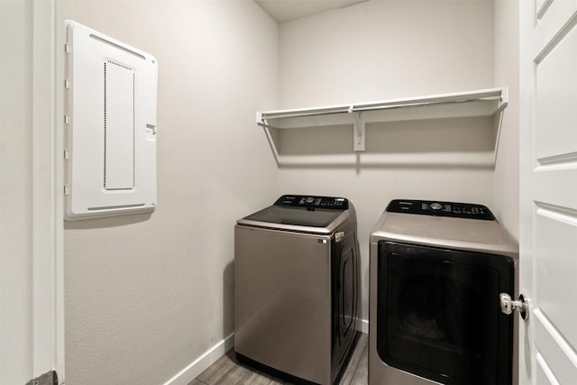 washroom featuring baseboards, washing machine and dryer, laundry area, and light wood-type flooring