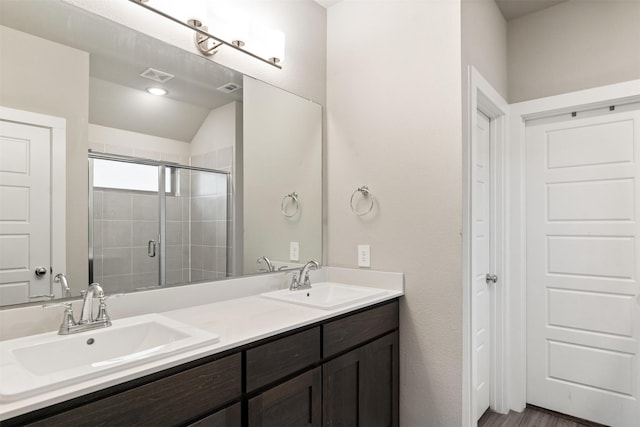 bathroom with a sink, visible vents, a shower stall, and double vanity