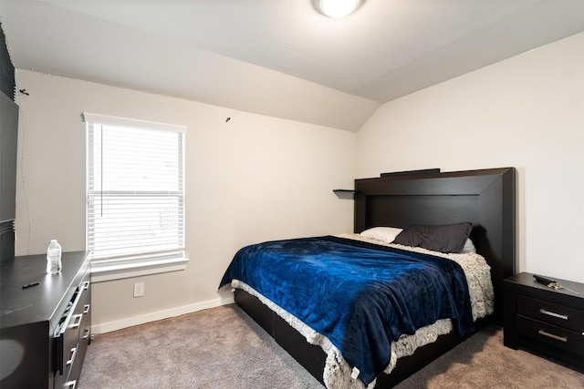 bedroom featuring light colored carpet, baseboards, and lofted ceiling