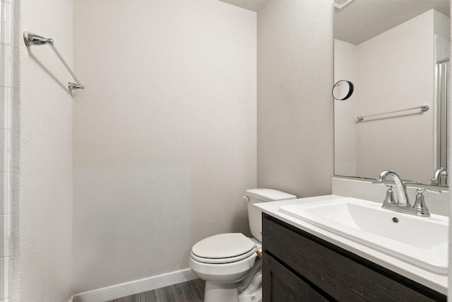 full bath featuring vanity, baseboards, toilet, and wood finished floors