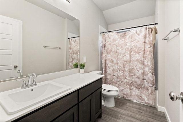 bathroom featuring toilet, vanity, lofted ceiling, wood finished floors, and shower / bath combo with shower curtain