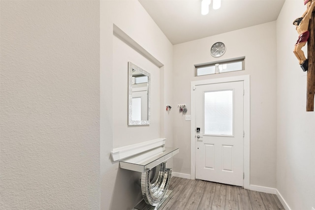 entryway with baseboards and light wood-style floors