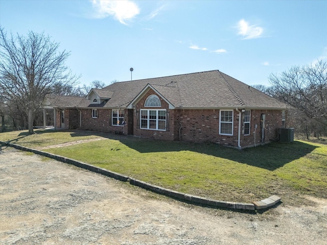 ranch-style home featuring central air condition unit, brick siding, roof with shingles, and a front lawn