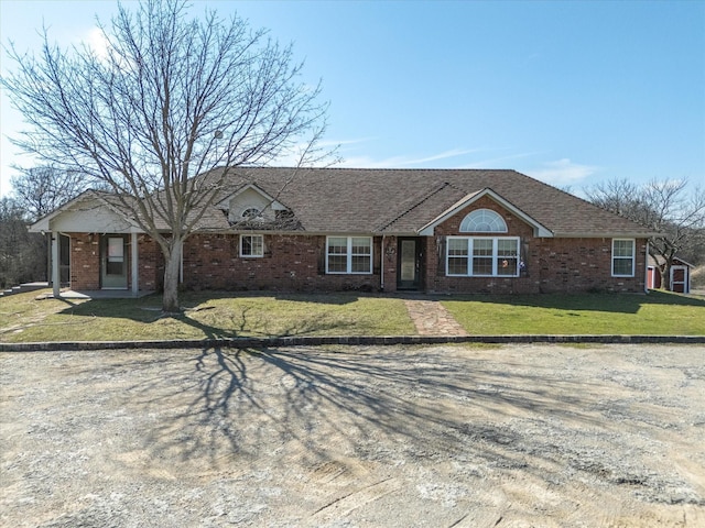 single story home with a front lawn, brick siding, and a shingled roof