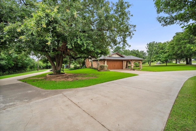 view of front of property with brick siding, a front lawn, an attached garage, and driveway