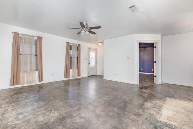 unfurnished room with ceiling fan, visible vents, baseboards, and concrete flooring